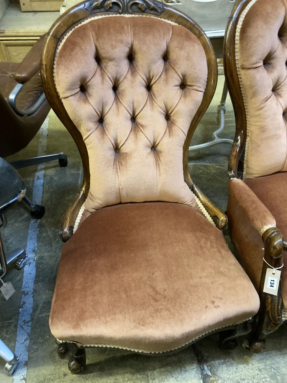 A pair of Victorian walnut spoon back button back chairs (one with arms)